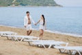 Attractive couple in white walking along seashore Royalty Free Stock Photo