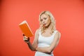 Attractive curly blonde woman reading book while standing Royalty Free Stock Photo