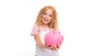 Attractive curly european girl holding a piggy bank in her hands on a light blue background