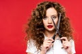 Attractive curly girl holding scissors, isolated