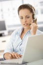 Attractive customer servicer using headphones Royalty Free Stock Photo