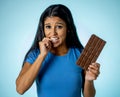 Attractive cute young woman with big bar of chocolate looking at it happy with temptation Royalty Free Stock Photo