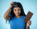 Attractive cute young woman with big bar of chocolate looking at it happy with temptation Royalty Free Stock Photo