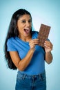 Attractive cute young woman with big bar of chocolate looking at it happy with temptation Royalty Free Stock Photo