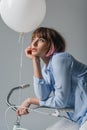 attractive dreamy girl sitting on bicycle with white balloon