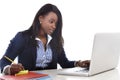 Attractive and efficient black ethnicity woman sitting at office computer laptop desk typing