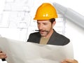 Attractive efficient and confident architect man in builder helmet checking building construction blueprints on design