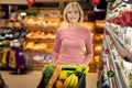 Attractive elderly woman choosing dairy products at supermarket Royalty Free Stock Photo