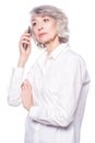 An attractive elderly woman listens very attentively to the interlocutor during a telephone conversation using a Royalty Free Stock Photo