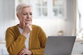 Attractive elderly woman sitting in front of laptop