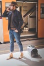 Attractive elegant young hispanic man holding smart phone in his hand and calling while he standing at the railway Royalty Free Stock Photo