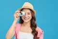 Attractive energetic Asian woman happily holding cemara isolated on blue studio background