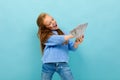 Attractive european girl throws money in hands on a light blue background