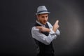 An attractive guy, in a retro suit and hat, crossed his arms showing two fingers. Royalty Free Stock Photo