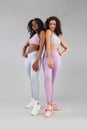 Two fitness women in sportswear isolated over gray background. Sport and fashion concept with copy space. Royalty Free Stock Photo