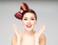 Attractive excited woman with a bow haircut and colorful make-up on grey background