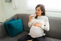 Pregnant woman taking a bite out of a chocolate bar Royalty Free Stock Photo
