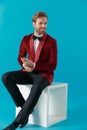 Attractive fashion man wearing red velvet tuxedo and looking to side Royalty Free Stock Photo