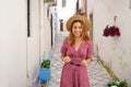 Attractive fashion woman walking looking down in narrow alley of typical old town of Italy