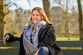 Attractive fashionable woman relaxing on a park bench in spring Royalty Free Stock Photo