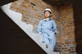 Attractive female construction worker in hardhat. Confident young specialist in checkered blue shirt in jeans standing Royalty Free Stock Photo