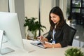 Attractive female customer service representatives wearing headset working on support hotline in modern workplace Royalty Free Stock Photo