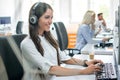 Attractive female customer support telephone operator working in call center. Royalty Free Stock Photo