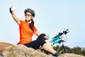 Attractive female cyclist taking a selfie photo outdoor.