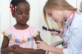 Female doctor checking skin of girl with special device.