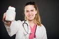 Attractive female doctor holding bottle of pills Royalty Free Stock Photo