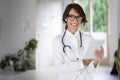 Attractive female doctor portrait while holding tablet in her hand and working at hospital Royalty Free Stock Photo