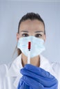 Attractive female doctor with virus protection mask and latex gloves carrying a syringe of the sars2 covid19 coronavirus vaccine