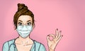 Attractive female doctor with virus protection mask looking straight ahead and showing ok sing.Doctor online.