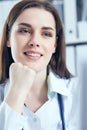 Attractive female doctor working on her laptop in her office. Happy doctor waiting for patient. Royalty Free Stock Photo