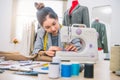 Attractive female fashion designer hand working in workshop with sewing machine. Stylish fashionista woman creating new cloth Royalty Free Stock Photo