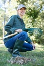 attractive female gardener raking leaves Royalty Free Stock Photo