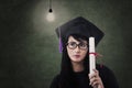 Attractive female graduate with certificate and lit bulb Royalty Free Stock Photo