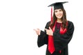 Attractive female graduate pointing with both fingers to a white space