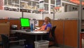Attractive female Homedepot worker typing information with green screen computer