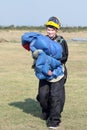 Attractive female sky diver posing with bright blue parachute an