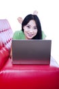 Attractive female smiling on red sofa - isolated Royalty Free Stock Photo