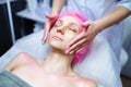 Attractive female at spa health club getting a facial massage. Beautician doing massage of face, neck and shoulders Royalty Free Stock Photo