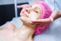Attractive female at spa health club getting a facial massage. Beautician doing massage of face, neck and shoulders Royalty Free Stock Photo
