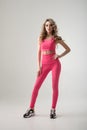 Pretty woman in pink leggings and top on white background Royalty Free Stock Photo