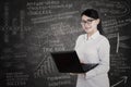 Attractive female student and written blackboard