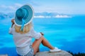 Attractive female tourist with turquoise sun hat enjoying amazing azure seascape, Greece. Cloudscape shadows on the sea