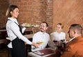 Waitress placing order in front of guests Royalty Free Stock Photo