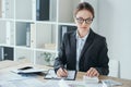 attractive financier working at table in office with calculator