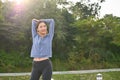 Attractive fit Asian woman in sportswear stretching her body after running in the nature park Royalty Free Stock Photo