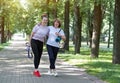 Attractive fit senior women enjoying doing sports together standing in the street sharing funny stories laughing and smiling on